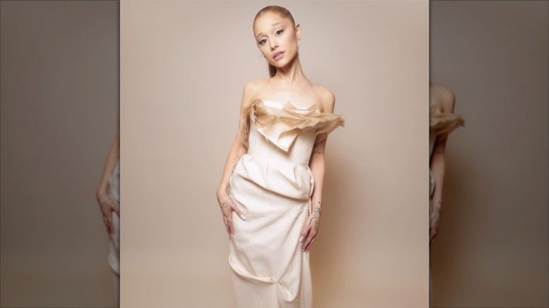 Ariana Grande in a deconstructed pink dress in front of a pink background.