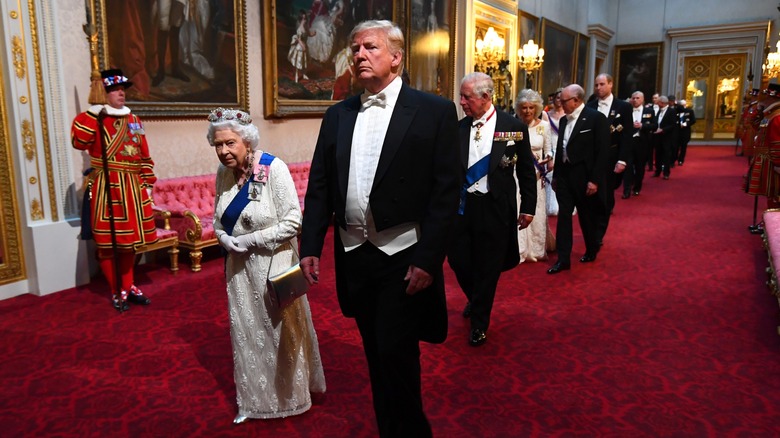 Donald Trump walking beside Queen Elizabeth II in 2019