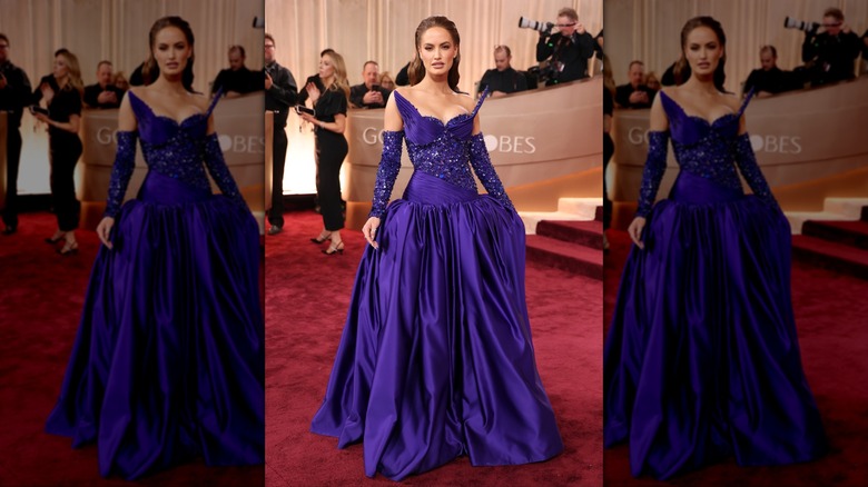 Haley Kalil posing in a purple gown with wing-like details on the bust.