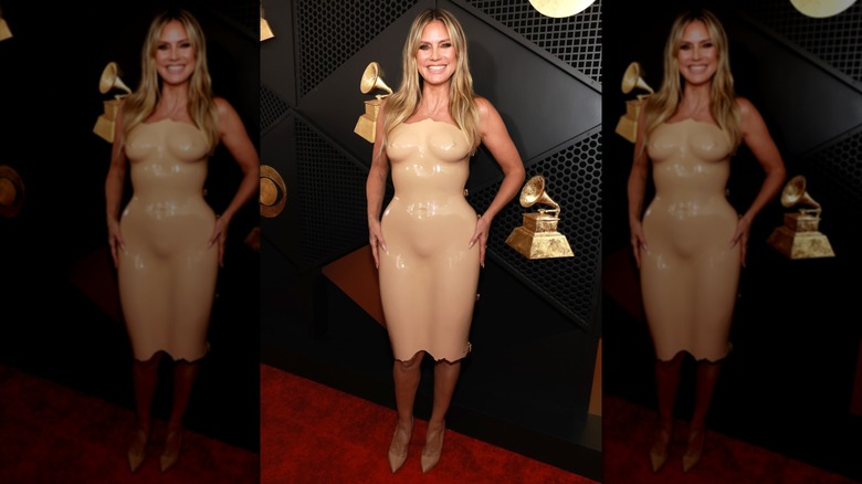 Heidi Klum posing in a shiny beige dress.