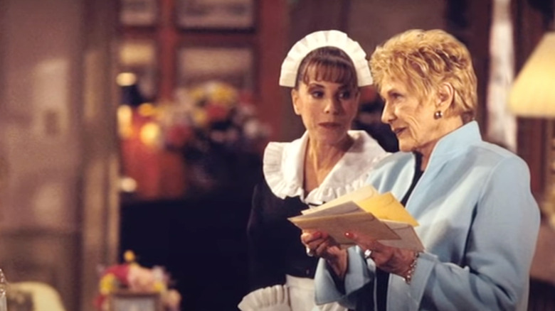 Esther in a maid uniform looking at Kay