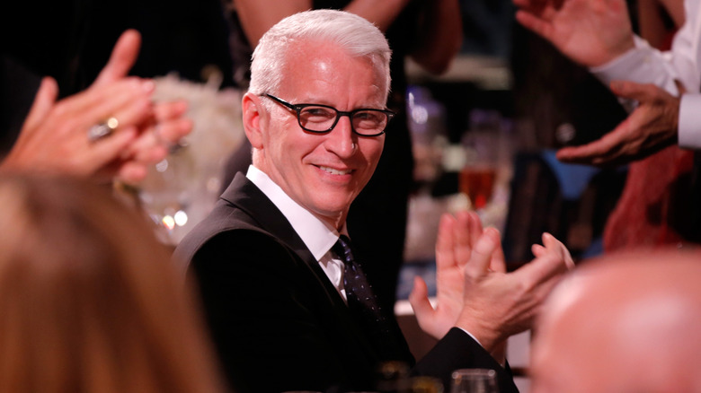 Anderson Cooper smiling and clapping his hands