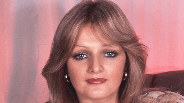Bonnie Tyler posing against a pink background in 1977