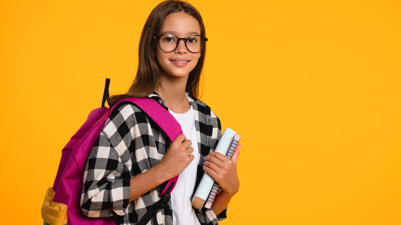 Girl with glasses carrying pink backpack 