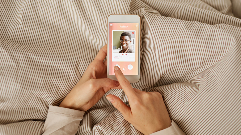 Woman wipes on dating app in bed