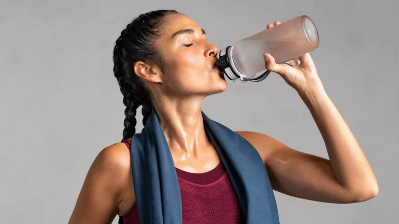 Sweaty woman drinking water 