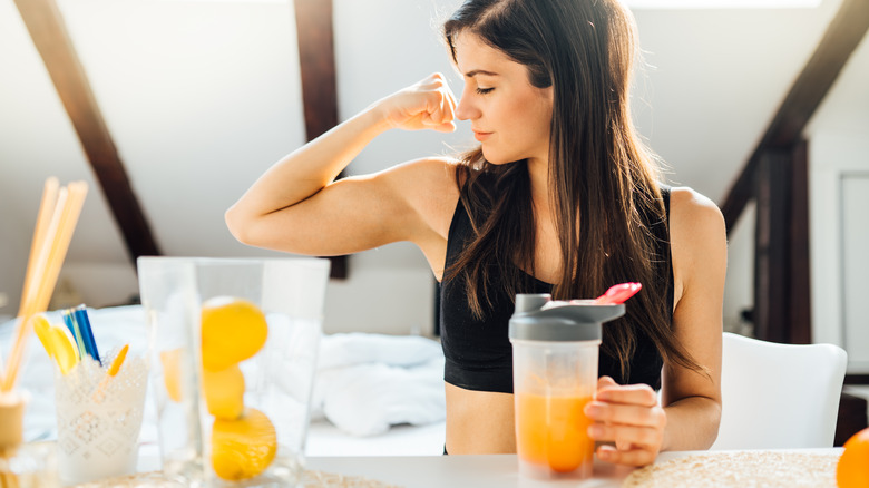 Woman flexing with workout shake