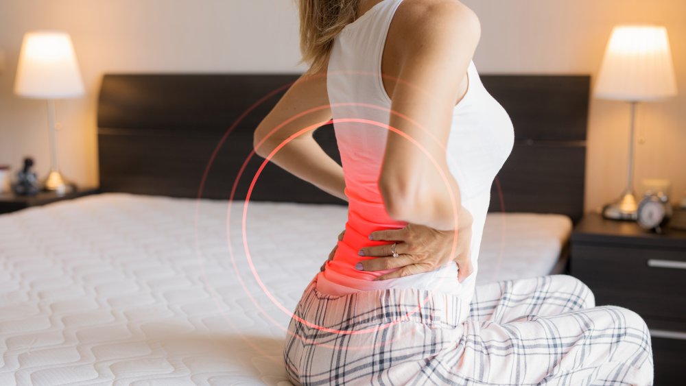 Woman on bed with back pain