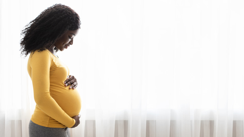 woman holding her baby bump 