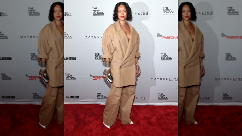 Rihanna in a brown suit at the red carpet for the Parsons Benefit