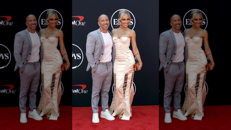 Jason Oppenheim wearing a casual gray suit posing with Mary Bonnet wearing an intricate dress at the 2024 ESPYs.