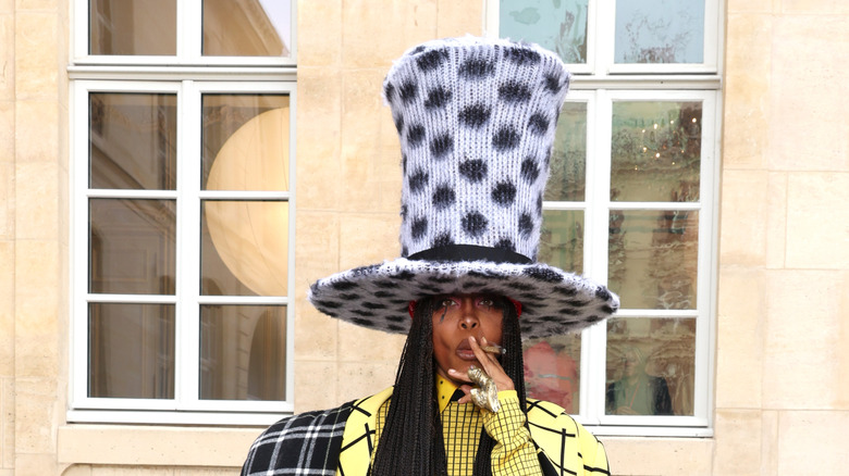 Erykah Badu wearing massive polka dot hat and smoking