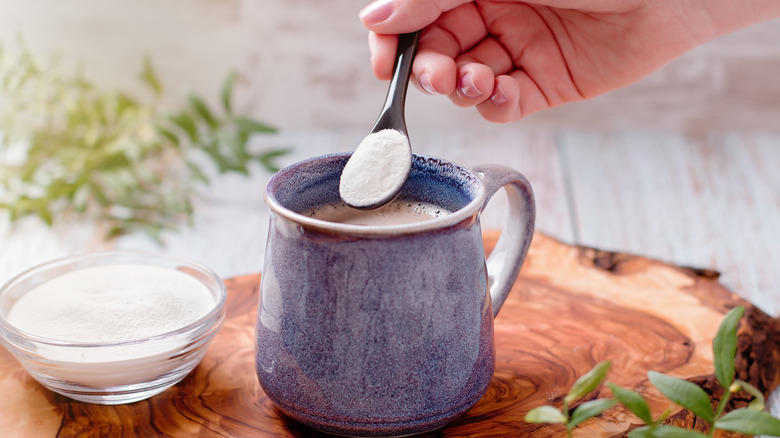 A woman adding collagen supplement to coffee
