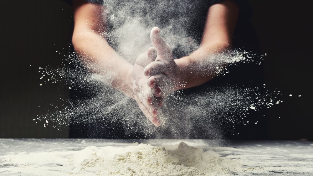 a mans hands filled with flour 