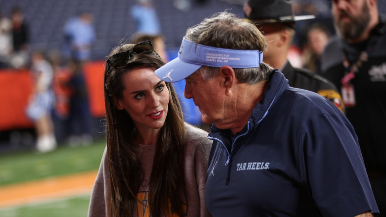 Bill Belichick and Jordon Hudson looking at each other and speaking