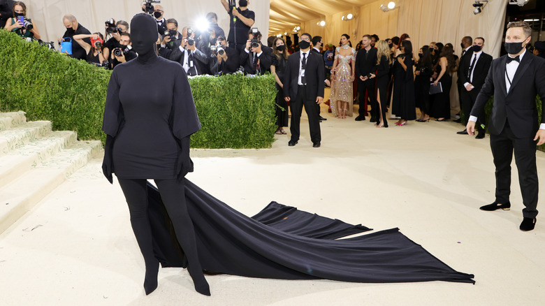 Kim Kardashian posing in all black outfit and head cover at the Met Gala
