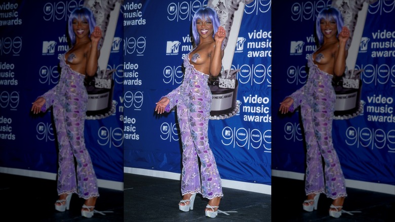 Lil' Kim waving on step-and-repeat at 1999 VMAs