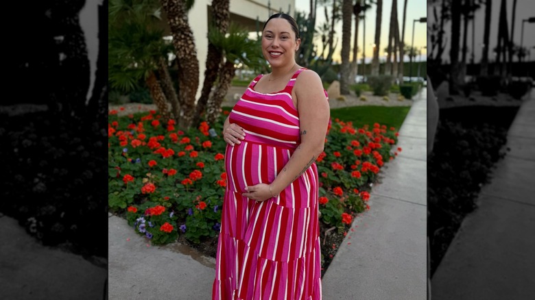 Alaina Scott clutching her baby bump in 2026