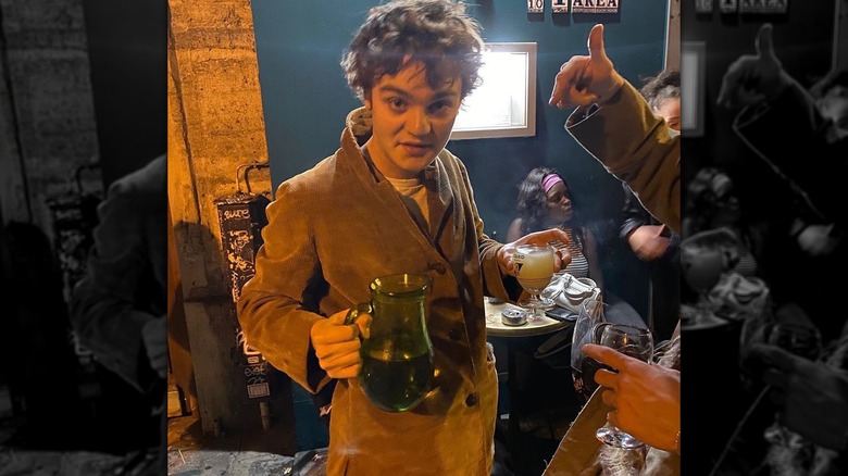 Jack Depp posing while carrying drinks at a restaurant in 2021