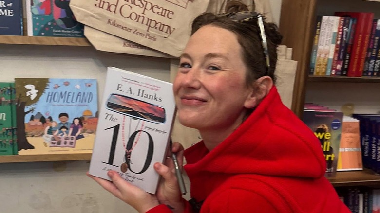 E.A. Hanks holding her book, "The 10," in 2025