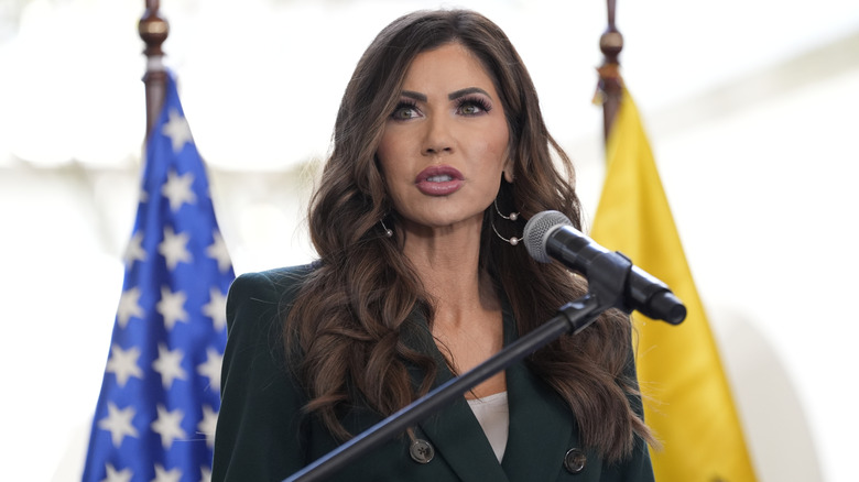 Kristi Noem giving a speech in a black blazer