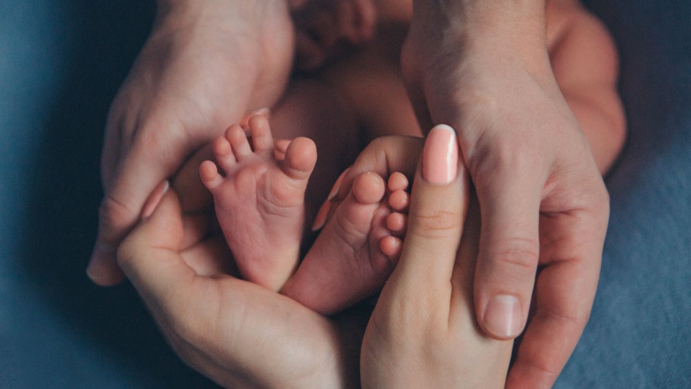 Mother holding newborn baby's feet