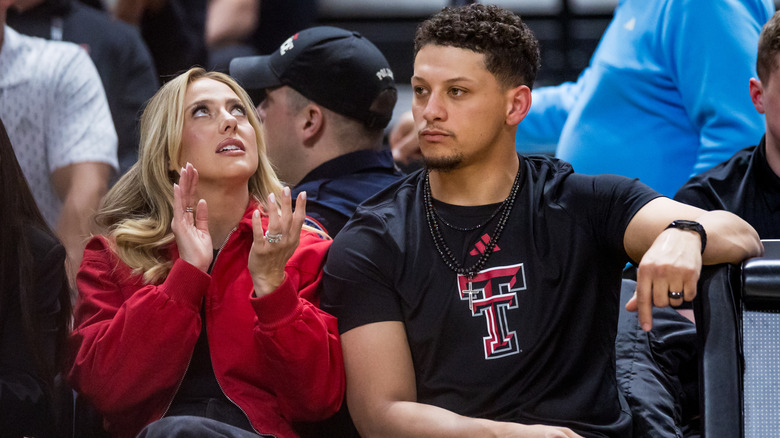 Brittany Mahomes and Patrick Mahomes sitting at sporting event