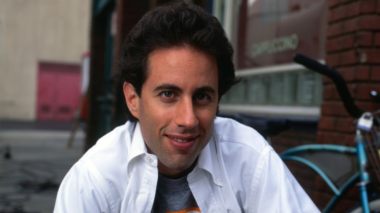 Jerry Seinfeld next to a blue bicycle
