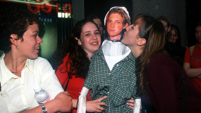 Hanson fans posing with an inflatable doll of Taylor Hanson