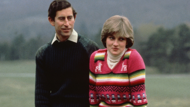 Princess Diana smiling shyly next to a smiling Prince Charles