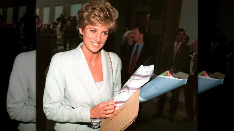 A smiling Princess Diana holding a bouquet of flowers