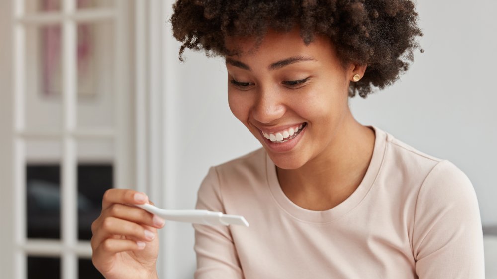 A woman holding a pregnancy test