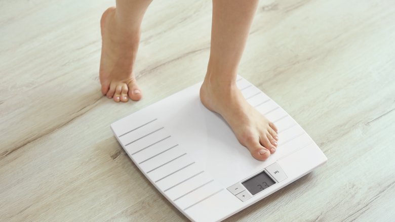 woman stepping on scale