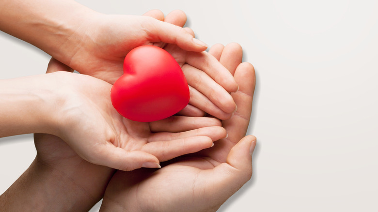 Adult and child hands holding heart