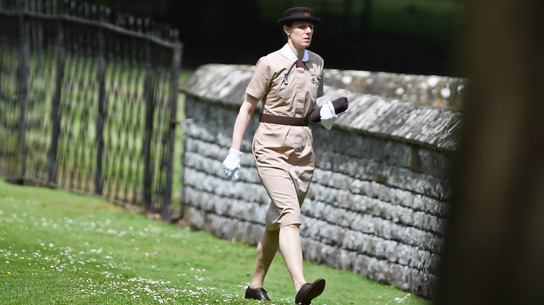 Maria Borrallo walking across lawn in her Norland College uniform