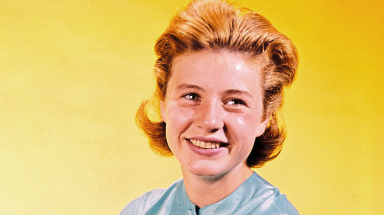 Patty Duke in front of a yellow background