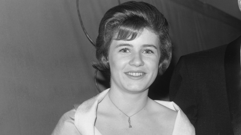 Patty Duke wearing a necklace in a black and white photo