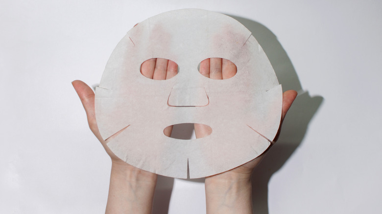 A woman holding a sheet mask