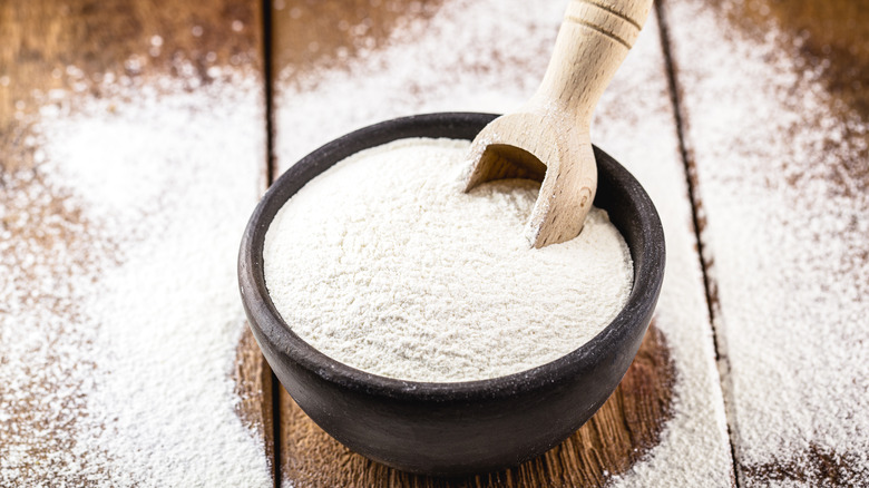 A bowl of flour on a wooden table