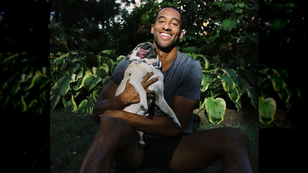 Matt James smiles with a dog