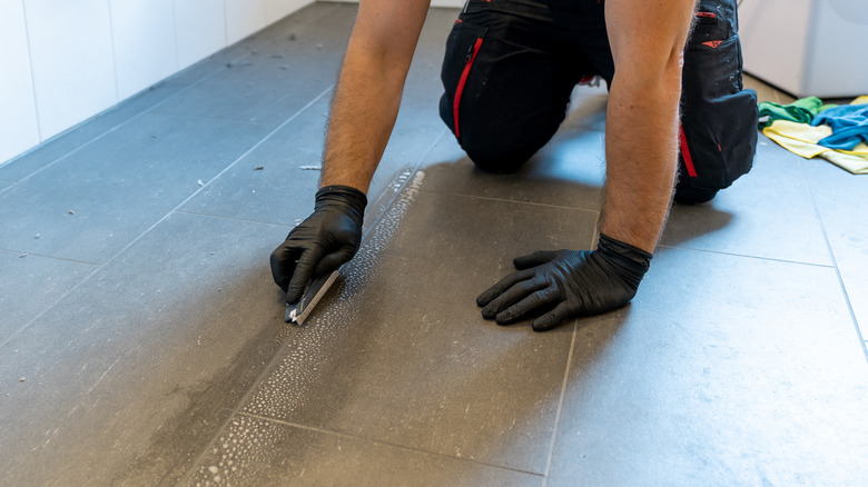 Man is scrubbing grout out