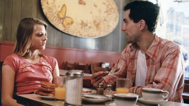 Jodie Foster and Robert De Niro sitting at a table on the set of 'Taxi Driver'