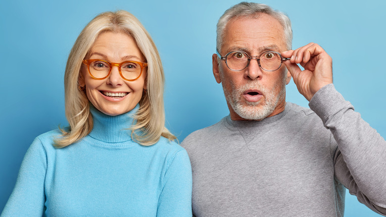 Happy older couple smiling on blue background