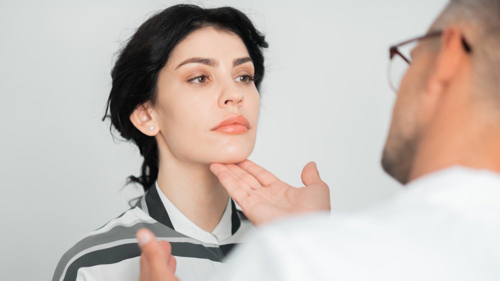 Plastic surgeon checking a woman's chin