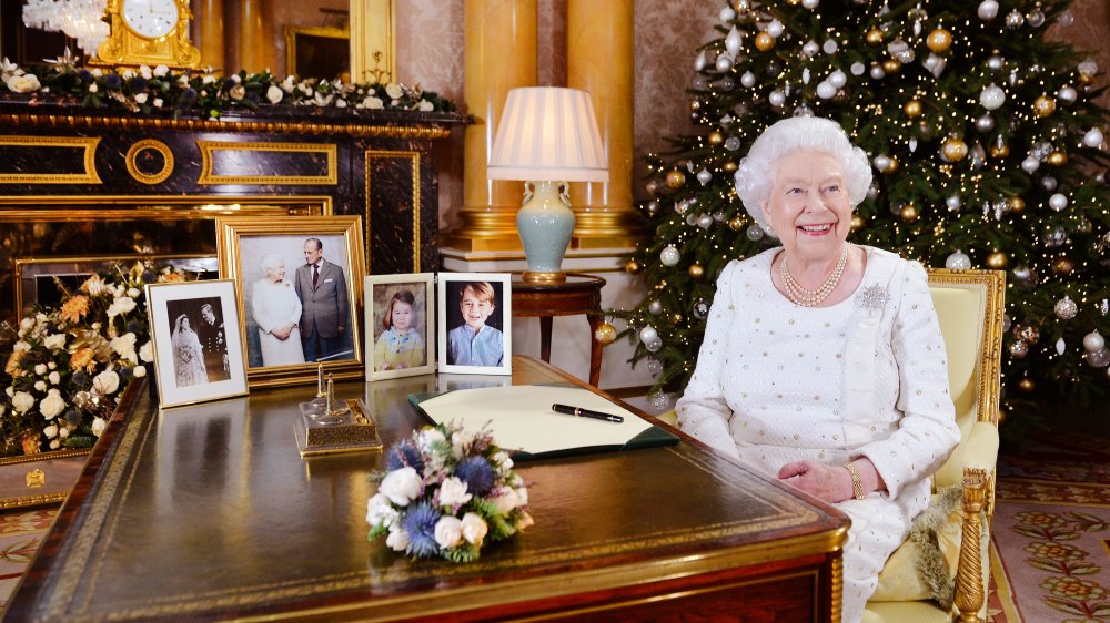 Queen Elizabeth at desk with photos