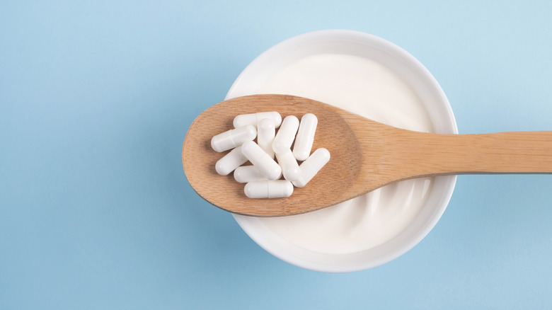 Spoon of probiotics over yogurt