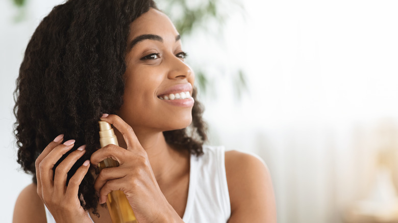 Woman applying a leave-in conditioner to hair