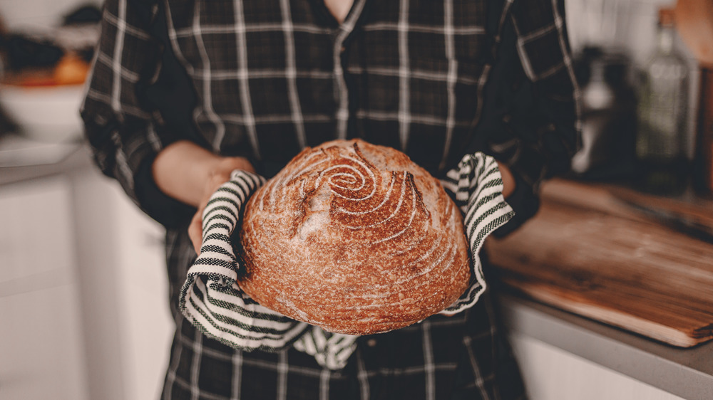 Person holding loaf of bread right out of oven