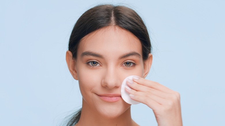 woman applying face product with pad