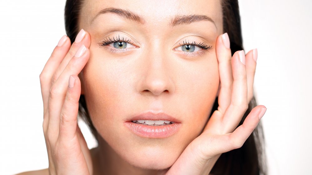 Woman touching the sides of her face 